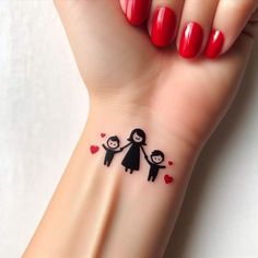 a small tattoo on the wrist of a woman with two children holding hands and hearts