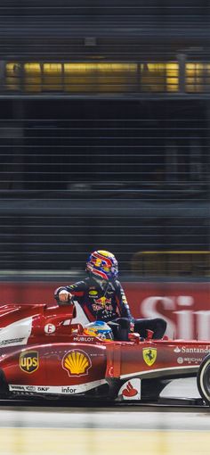 a man driving a red race car on a track