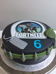 a cake that is sitting on top of a table with the name fortnite written on it