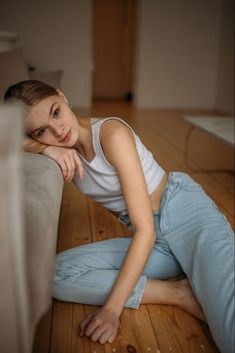 a young woman sitting on the floor with her arms crossed