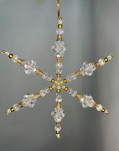 a gold and crystal snowflake hanging from a ceiling