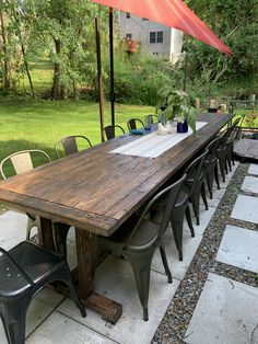 an outdoor dining table with chairs and an umbrella