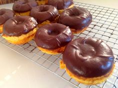 chocolate frosted doughnuts on a cooling rack ready to be baked in the oven