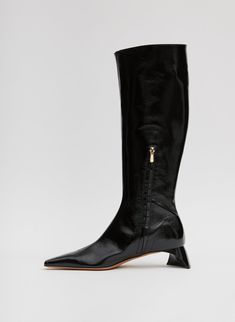 A knee-high boot designed to step you through Fall—and winter too—the Boris Boot features an ultra-shiny patent leather in hues across the Tibi Color Wheel and a total, semi-shiny heel for added depth, this style will single-handedly provide that good ick your closet craves. A zipper finish—because we know the work it takes getting a boot of this stature on and off—solidifies this style as a wardrobe must have, not only checking all three boxes of CMC, but providing a sturdy base for pushed PDW Winter Patent Leather Knee-high Heeled Boots, Fall Patent Leather Knee-high Heeled Boots, Modern Patent Leather Knee-high Boots, Knee-high Patent Leather Heeled Boots For Fall, Fall Knee-high Patent Leather Heeled Boots, Modern Knee-high Patent Leather Boots, Evening Patent Leather Knee-high Heeled Boots, Winter Knee-high Patent Leather Boots, Modern Patent Leather Knee-high Boots For Formal Occasions