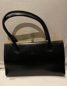 Here is a beautiful black FREEDEX vintage 1940s -50s ladies double top handle handbag / purse. This beautiful handbag has a gold coloured metal frame. Also is lined in black fabric with 1 pocket, this is a beautiful vintage FREEDEX handbag.  A great vintage piece for All you great vintage lovers  Label :   FREEDEX  Measurements :   Approximately  Height :  6 -  Inches  Length :  10 - 3  -  Inches  Condition :   Good vintage condition  Couple of scratches over the handbag, gold coloured metal sli 1940s Bags Handbags, Vintage Purses 1950s, Vintage Bags 1950s, Vintage Bags And Purses, Purse Aesthetic, 1940s Shoes, Vintage Lovers, Black Handbag, Top Handle Bags