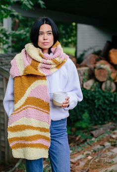 a woman wearing a scarf and holding a cup