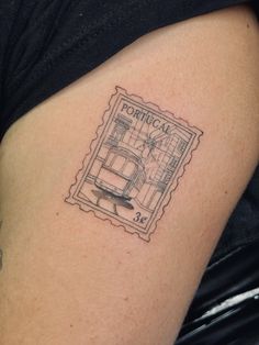 a postage stamp tattoo on the arm of a woman's left thigh, with an image of a kitchen