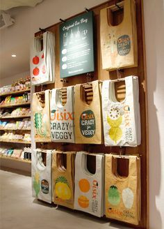 the grocery bags are hanging on the wall in front of the store's shelves