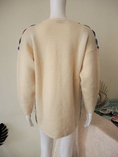 Beautiful True Vintage knit jumper from the 1980s/1990s. Vibrant floral crochet lace on the front, loose slightly oversized cut, off-white sleeves and back. Small shoulder pads (easily removable thanks to velcro fastening). Looks great with a pair of jeans and hiker boots. BRAND: Pregi ERA: 1980s, 1990s COLOR: Off-white, multicolor e.g. blue, red, sand, black, rust, grey FABRIC: 100% wool SIZE: No size tag, fits best a size M MEASUREMENTS: Pit to pit 56cm, total length 70cm CONDITION: Good to ve Bohemian Fair Isle Sweater For Spring, Oversized Bohemian Crew Neck Sweater, Bohemian Crew Neck Knit Cardigan, Cream Long Sleeve Bohemian Sweater, Oversized Vintage Cream Sweater, 80s Grandma Sweater, Handmade Multicolor Vintage Sweater, 1980s Cardigan, Vintage Multicolor Acrylic Sweater