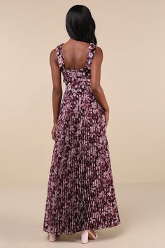 a woman in a purple floral print dress looking down at the back of her dress