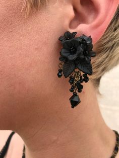 Pretty Floral Black Earrings, hand beaded with glass beads and hand painted resin flowers. A cluster of flowers hugs the earlobes and are finished with jet black beads as a drop. This is a quality piece of jewelry that will last a life time. Created by designer Colleen Toland who has been creating her unique style of vintage jewelry for more than 30 years. Earrings measure .75 inches by 1.25 inch. All metal components are nickel free and are plated in antique gold. All our post earrings are hypo Black Bohemian Dangle Flower Earrings, Bohemian Black Dangle Flower Earrings, Black Hand Painted Drop Earrings, Handmade Black Dangle Clip-on Earrings, Bohemian Black Flower Earrings For Gift, Adjustable Black Bohemian Flower Earrings, Handmade Black Wedding Earrings, Bohemian Black Flower Jewelry, Handmade Black Drop Flower Earrings