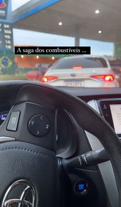 the dashboard of a car with an electronic device in it's center console, next to a gas station