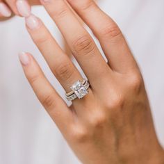 a woman's hand holding an engagement ring