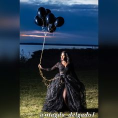 a woman in a long black dress holding balloons with the caption, magic delegadlo