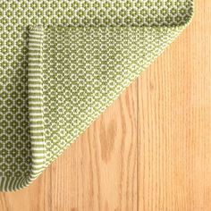 a green and white table cloth on top of a wooden floor