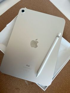 an apple ipad with a pen sitting on top of it