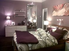 a bed room with a neatly made bed and purple walls