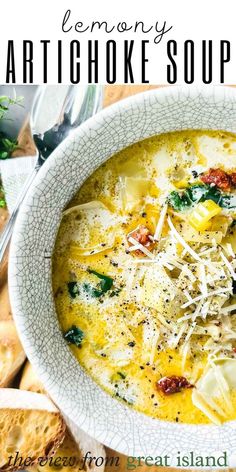 a bowl of artichoke soup with bread and parmesan cheese on the side