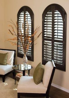 a living room filled with furniture and windows covered in plantation shutters, along with a coffee table