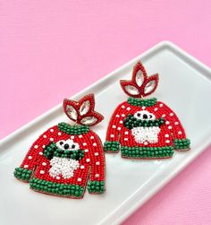 The Beaded Ugly Christmas Sweater Earrings are a whimsical and festive accessory that adds a touch of holiday cheer to any outfit! These adorable earrings feature a cute white penguin nestled on a colorful, bead-embellished ugly Christmas sweater design, bringing joy and laughter to the holiday season. Crafted with meticulous attention to detail, our Beaded Ugly Christmas Sweater Earrings showcase vibrant beads that capture the spirit of the season. The intricate beadwork recreates the iconic el Christmas Beaded Earrings As Gift, Christmas Gift Beaded Earrings, Handmade Beaded Earrings For Christmas Holiday, Handmade Beaded Earrings For Christmas, Handmade Beaded Earrings For Christmas Party, Handmade Beaded Earrings For Holiday Party, Cute Christmas Festive Jewelry, Cute Christmas Holiday Jewelry, Red Beaded Earrings For Holiday Party