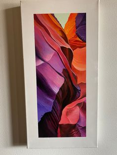 a painting hanging up on the wall next to a white framed art print with an abstract design