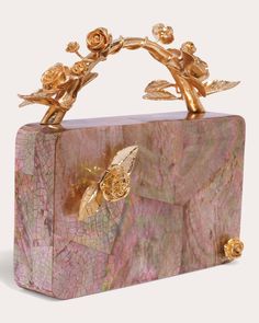 Hand-carved from gorgeous mother of pearl, the Boboli clutch exudes sophisticated elegance. Eluding to floral inspiration, the branch-like top handle and budding rose details are brought to life in plated 14-karat gold for a statement finish. Includes removable chain strap Magnetic closure Floral applique Vine top handle 14k gold-plated brass details Outer: mother of pearl Lining: matte satin Store in dust bag Made in the Philippines Measurements Width: 6.29in Height: 4.33in Depth: 1.96in Removable strap drop: 22in Rose Clutch, Hand Bags For Women, Pearl Clutch, Bridal Bag, Rosé Details, Fancy Bags, Box Clutch, Matte Satin, Pearl Shell