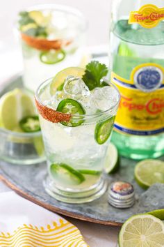 two glasses filled with limeade and garnish on top of a metal tray