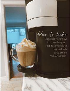 a cup of coffee sitting on top of a counter next to an espresso machine