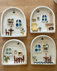 four plates with miniature houses painted on them