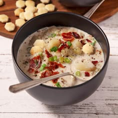 a bowl of soup with potatoes and bacon in it