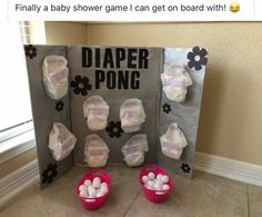 two buckets filled with white balls next to a diaper pong display