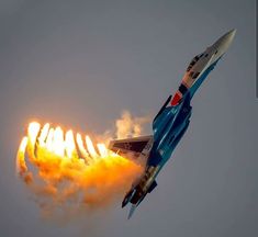 a jet flying through the air with flames coming out of it's back end