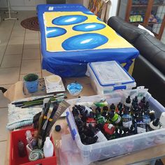 the table is covered with various crafting supplies, such as paint and markers on it