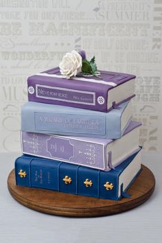 a cake made to look like books stacked on top of each other with a flower on top