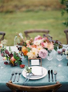 the table is set with flowers and silverware