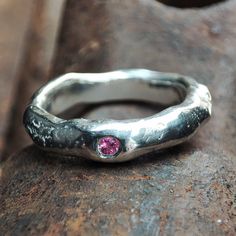 A volcanic silver ring with a 2mm Pink faceted sapphire. The flush-set faceted stone stands really nice against the free forms of the molten ring. We make each one of these rings individually from recycled silver. The AAAA-rated pink sapphire makes this ring really special.   This can be an everyday ring, a ring for special occassions, or an alternative wedding or engagement ring. The natural shapes and curves keep this very minimalistic ring really interesting (I should know... I've been wearin Silver Rings With Pink Sapphire Birthstone, Silver Pink Sapphire Ring With Birthstone, Silver Pink Sapphire Ring With Birthstone Details, How To Wear Rings, Precious Stones Rings, Engagement Wedding Ring, Etsy Wedding Rings, Everyday Rings, Recycled Silver