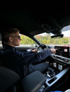 a police officer is sitting in the driver's seat of a car with his hand on the steering wheel