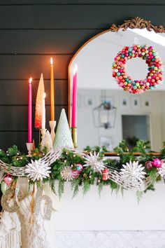 a mantle decorated with christmas decorations and candles