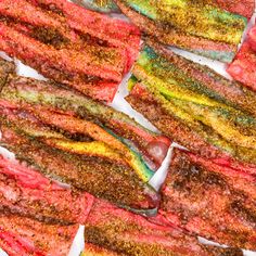 colorful strips of food sitting on top of a white plate with seasoning sprinkles