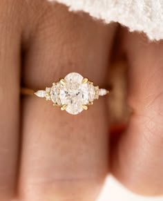 a woman's hand with a diamond ring on top of her finger and an engagement band