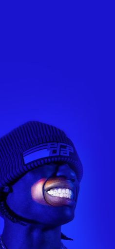 a man with his mouth open wearing a beanie and blue light up face paint