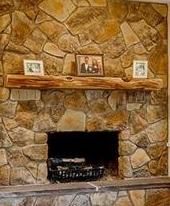 a stone fireplace with pictures on the mantle