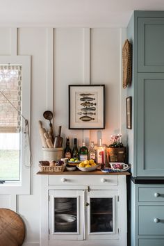 a kitchen with an oven, counter and pictures on the wall above it that is filled with cooking utensils