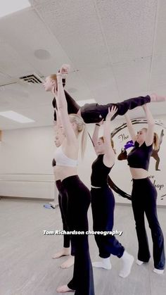 three women in black and white outfits are doing acrobatic tricks on the dance floor