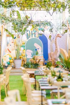 tables and chairs are set up for an outdoor party with balloons, greenery, and decorations