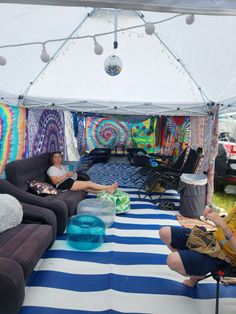 two people sitting on couches in a tent