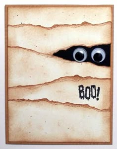 an image of two eyes peeking out from behind a piece of paper with the word boo written on it