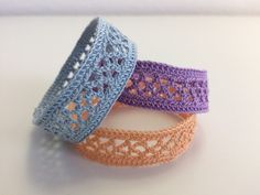 three crocheted bracelets sitting next to each other on top of a table