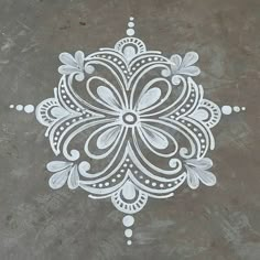 an intricate design is painted on the ground with white paint and grey cement behind it