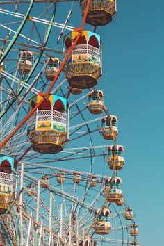 the ferris wheel is brightly colored and has people on it